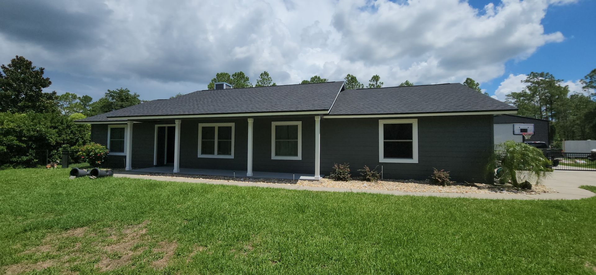 A ceiling fan is hanging from the ceiling of a covered patio.