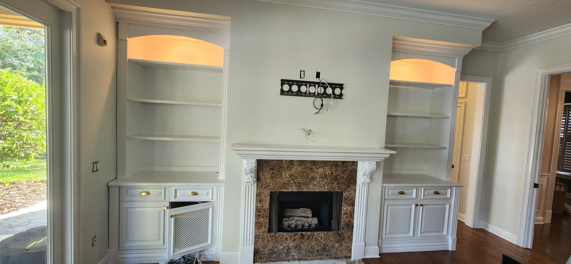 The back of a house with a covered porch and a white fence.